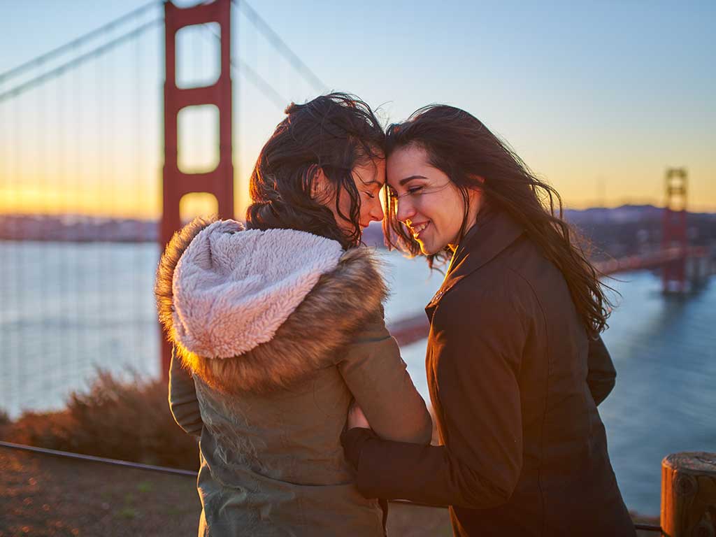 lgbt couple in front of bridge